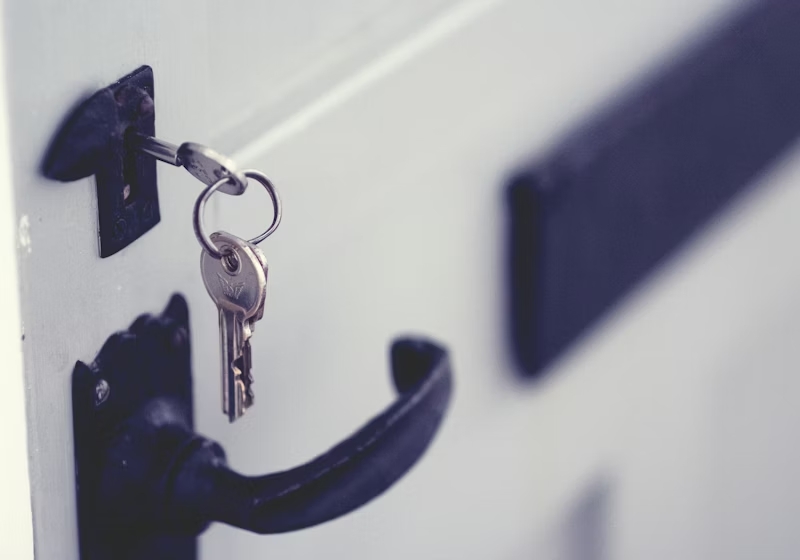 Cerrajero abriendo puerta residencial con herramientas profesionales